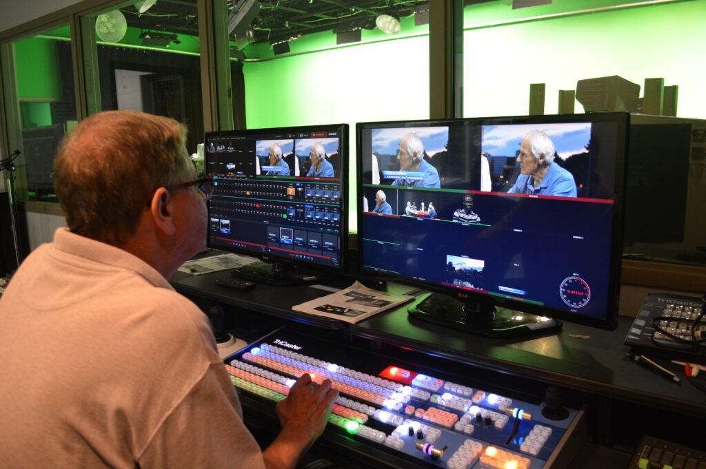 Person sitting at control room switcher and monitors