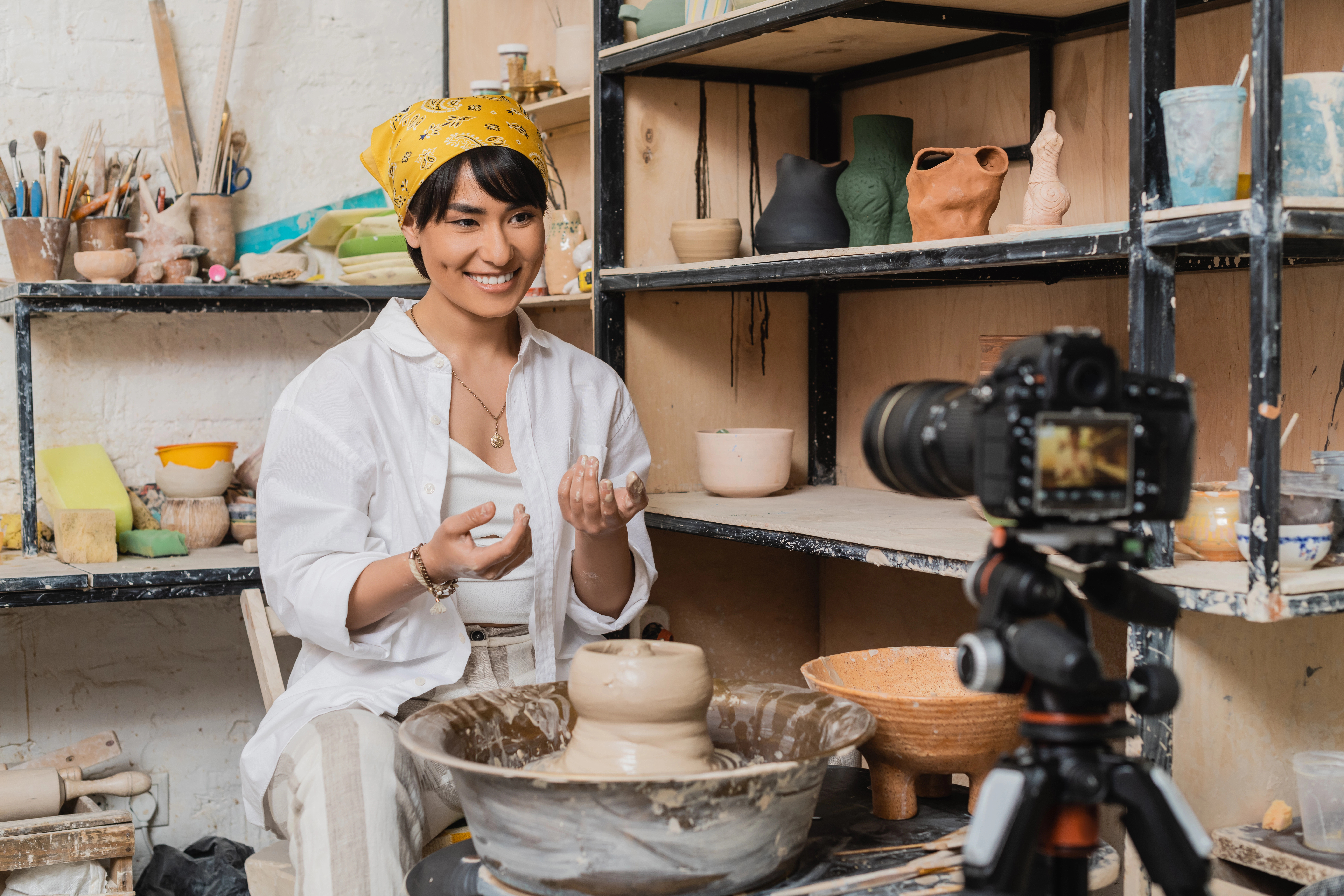 young artisan in headscarf with camera in foreground